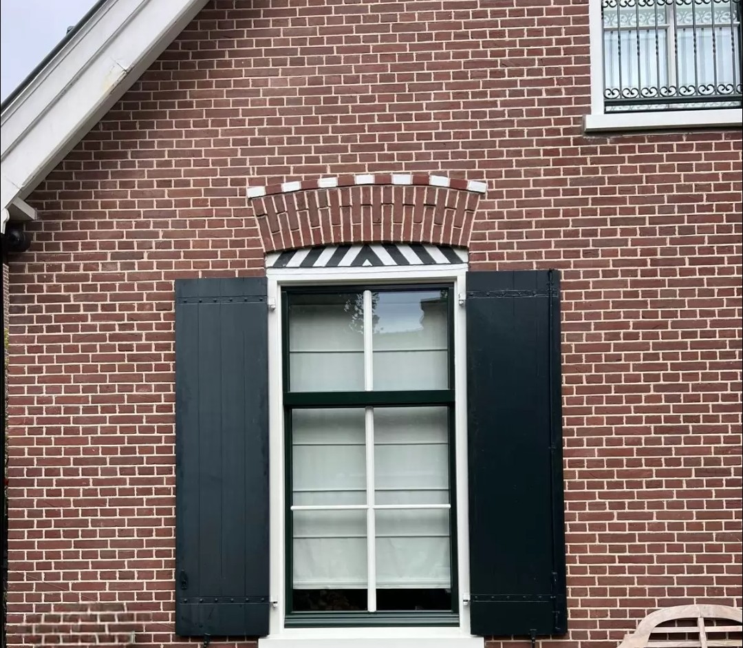 Klassieke woning met witte kozijnen en zwarte luiken in Castricum