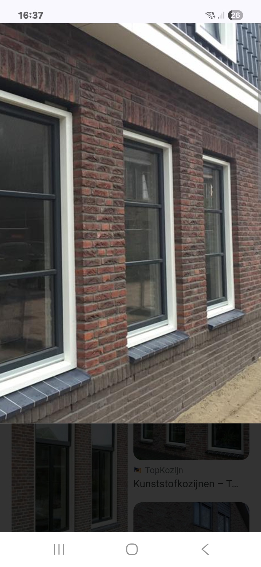 Strak wit geschilderde houten kozijnen in baksteen gevel